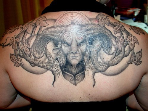 背部黑灰羊角怪物和树叶纹身图案
