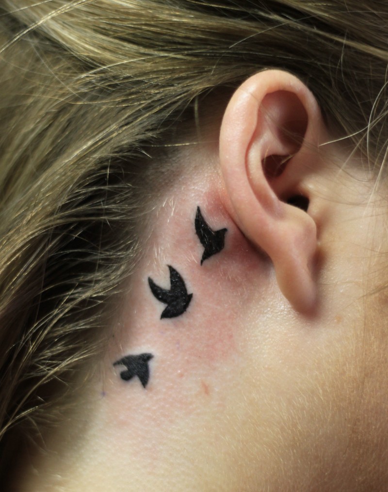 女士耳朵后面的小鸟纹身图案
