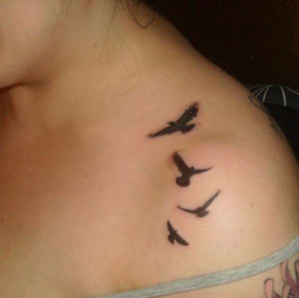 女孩肩部黑色的小鸟纹身图案