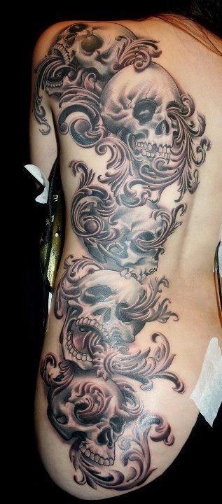 背部黑灰色的骷髅和花卉纹身图案