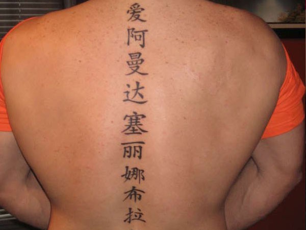 背部脊椎骨处黑色的汉字纹身图案