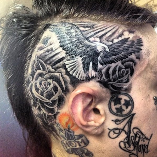 头部黑色的飞鹰与玫瑰纹身图案