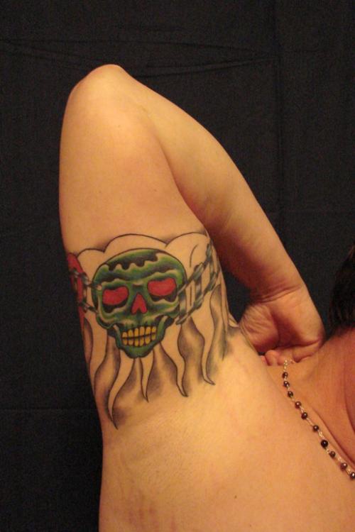 大臂内侧绿色的骷髅纹身图案