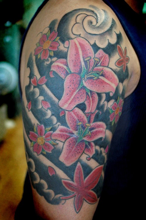 大臂粉红色的百合花和乌云纹身图案