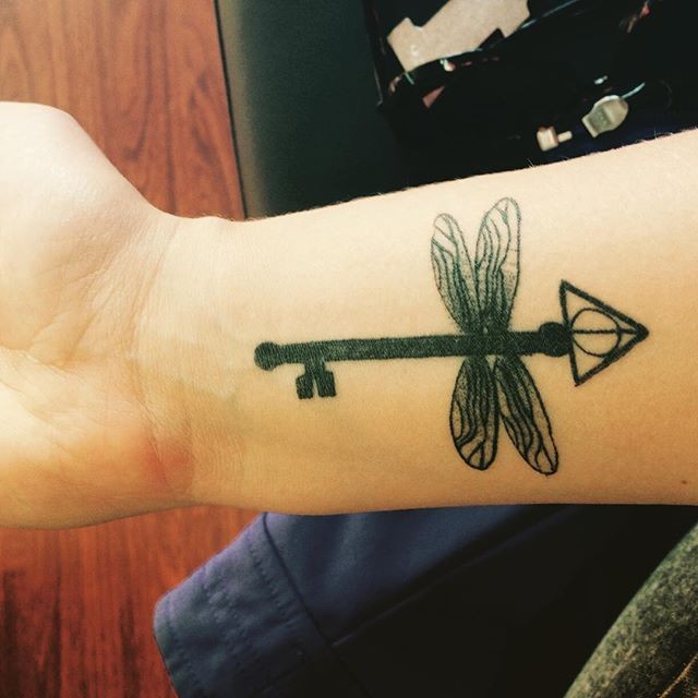手腕上神秘的蜻蜓形钥匙黑色纹身图案