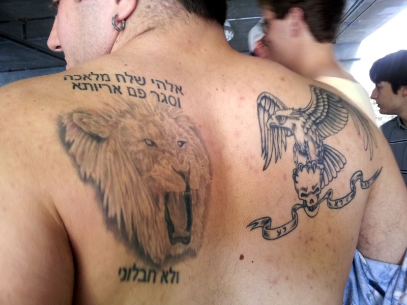 男性背部希伯来字符和狮子纹身图案