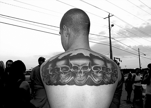 男性背部黑色的一排骷髅纹身图案