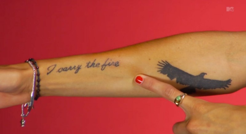 手臂黑色的字母和大鸟纹身图案