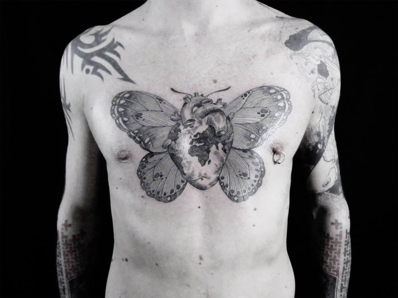胸部黑墨色的蝴蝶翅膀与心脏纹身图案