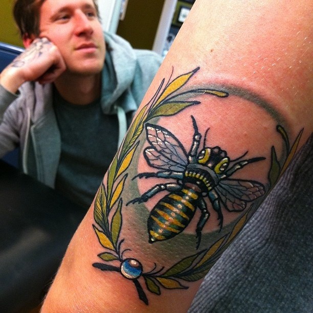 手臂彩色的蜜蜂和树叶纹身图案