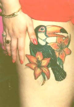 大腿彩色的鹦鹉与百合花纹身图案