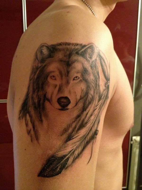 手臂上有羽毛的狼头纹身图案