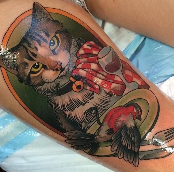 大腿滑稽的猫与餐盘上的小鸟纹身图案