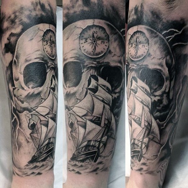 黑白巨大的骷髅和海面帆船手臂纹身图案