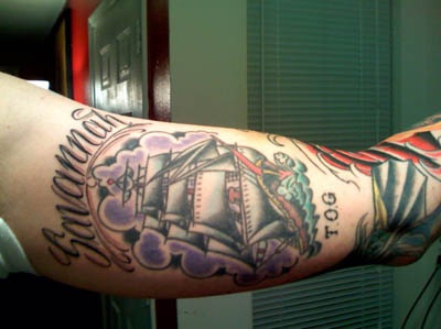 大臂内侧彩绘帆船和字母纹身图案