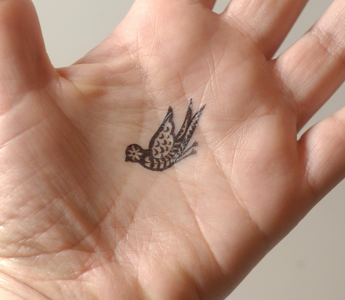 手掌上小小的鸟纹身图案