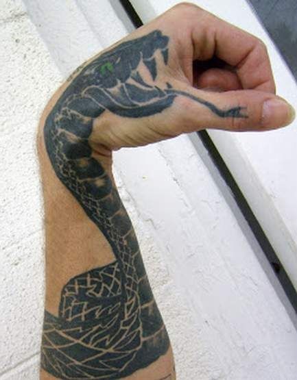 手臂上有绿色眼睛的黑蛇纹身图案