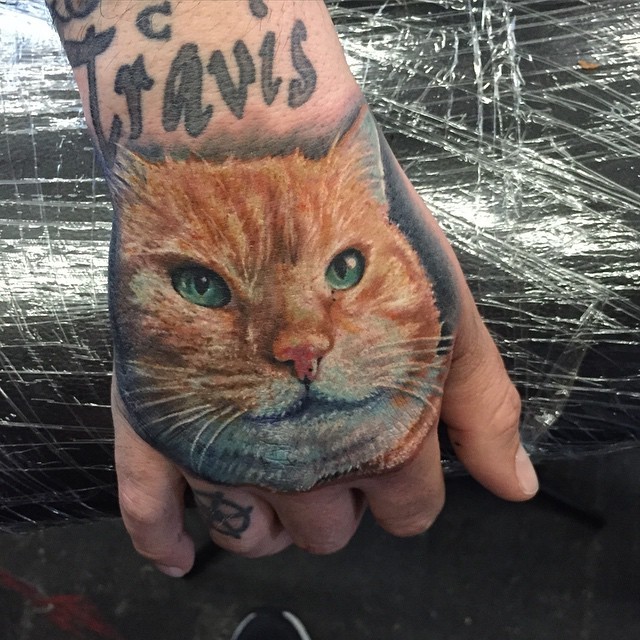 手背写实风格的彩色猫头纹身图案