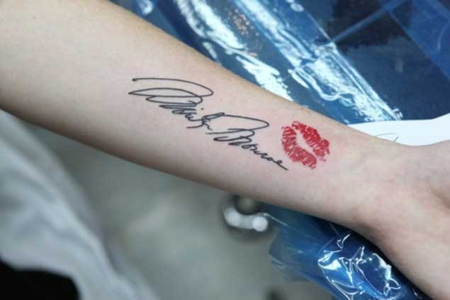 手腕黑色名人签名字母和红唇印纹身图案