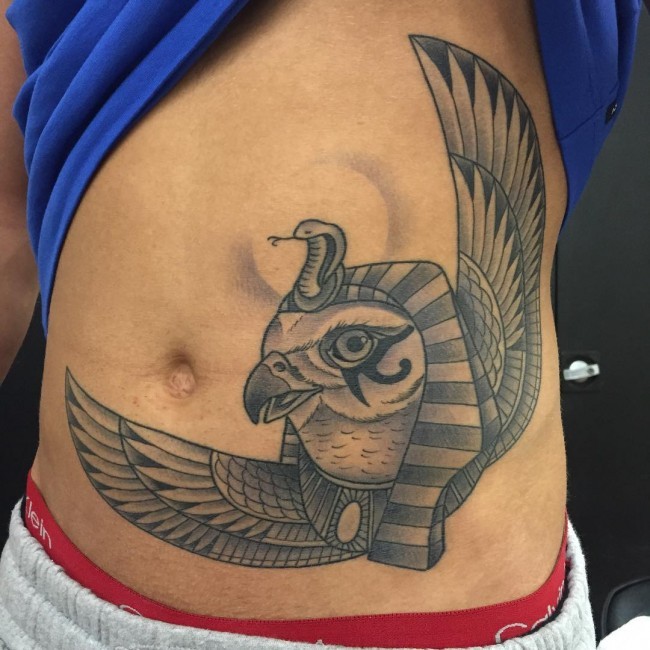 腹部黑色的埃及神鸟和蛇雕像纹身图案