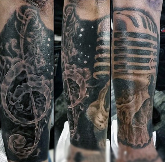 大臂神秘的黑色骷髅与麦克风音符纹身图案
