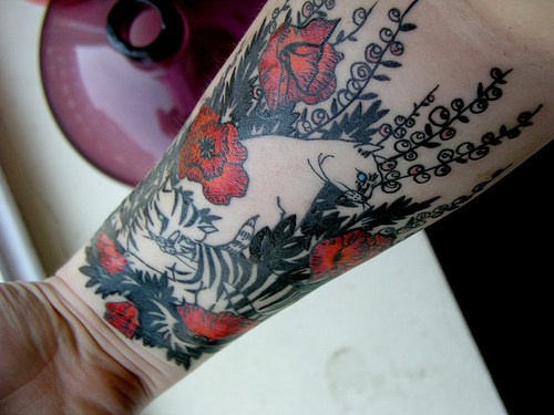 手腕罂粟花和白色猫纹身图案