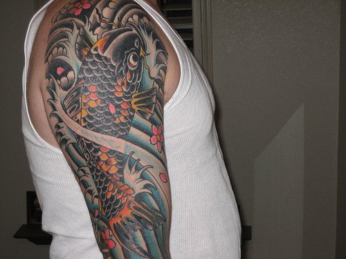 手臂黑色的鲤鱼和花朵海浪纹身图案