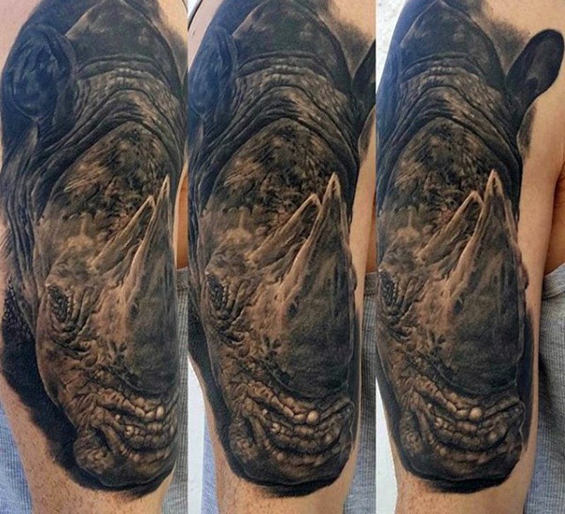 手臂惊人的写实黑色大犀牛头纹身图案