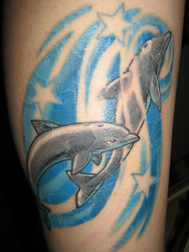 两只海豚在蓝色的波浪上点缀着星星纹身图案