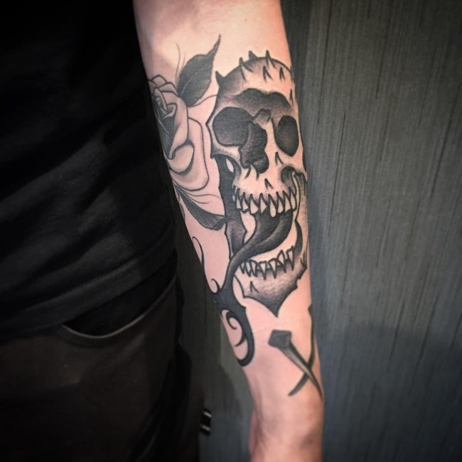 手臂插画风格黑色骷髅与花朵纹身图案