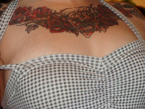 胸部扭曲玫瑰和心脏纹身图案