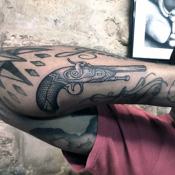 小臂黑色雕刻风格手枪纹身图案