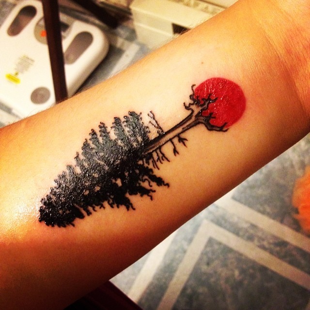 小臂小小的黑色树与红太阳纹身图案