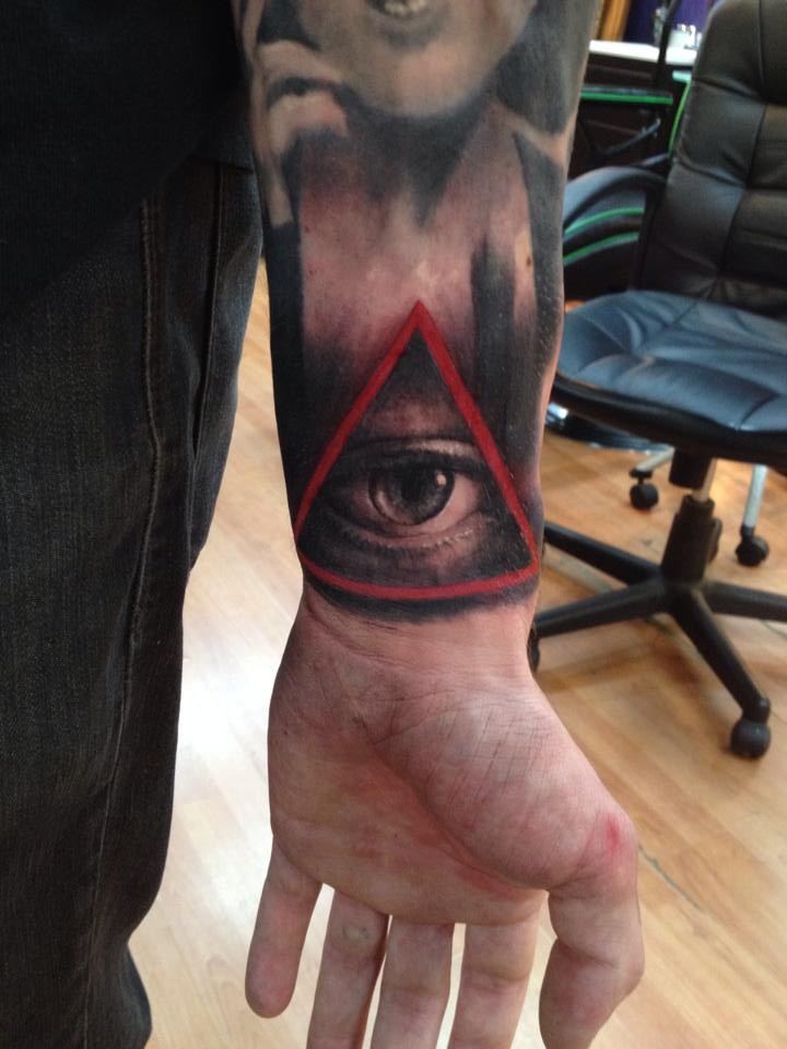 手臂黑灰眼睛与红色三角形纹身图案