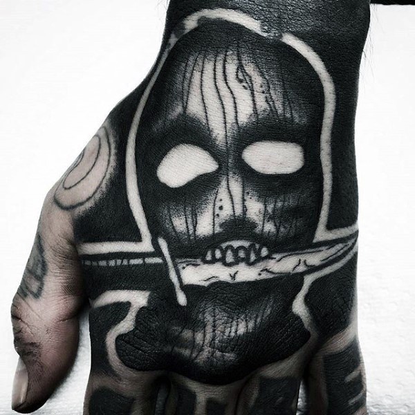 手背黑色疯狂的面具与匕首纹身图案