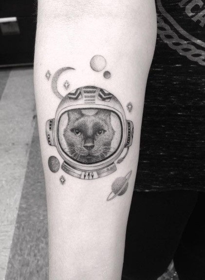 手臂卡通风格的黑灰太空猫与行星纹身图案