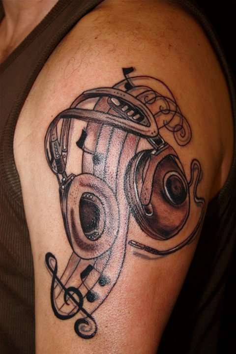 大臂雕刻风格黑色耳机和音符纹身图案