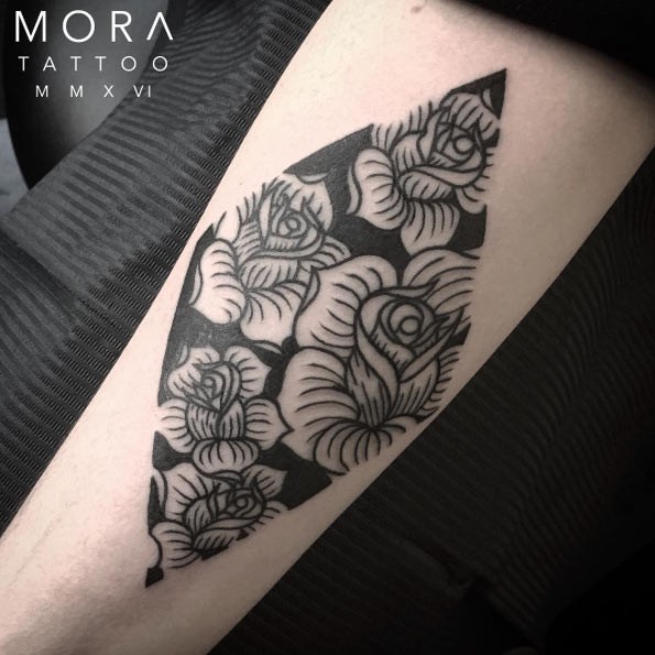 手臂黑色的几何形状与各种花卉纹身图案