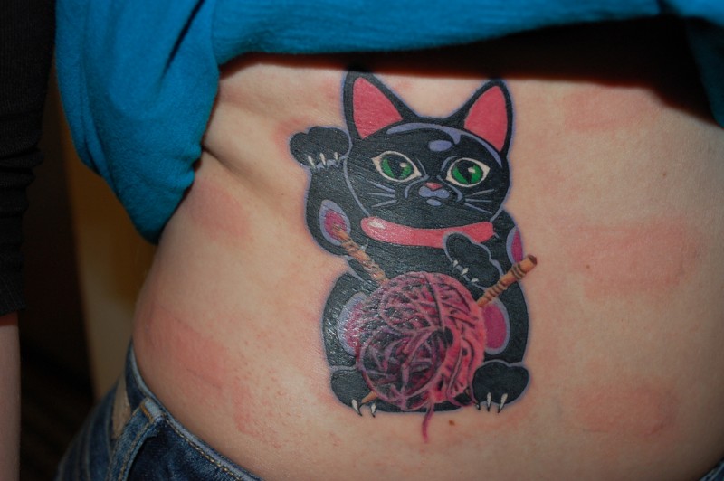 后背黑色的招财猫和毛线球纹身图案