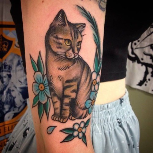 坐在花朵旁的猫纹身图案