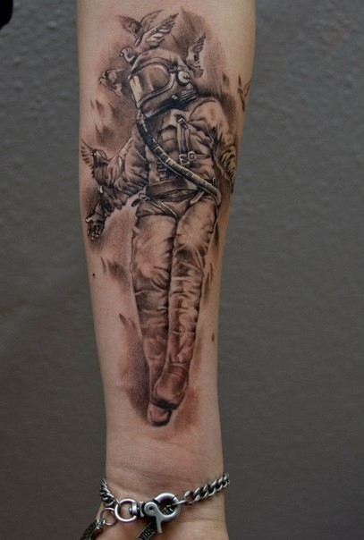小臂独特的黑色宇航员与鸽子纹身图案