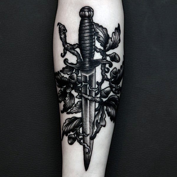 小臂黑色雕刻风格匕首与树叶纹身图案