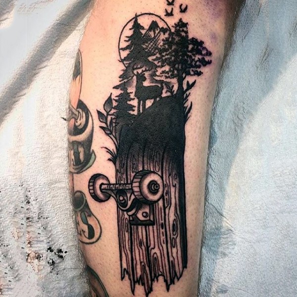 腿部黑色壮观的木质滑板和树木纹身图案