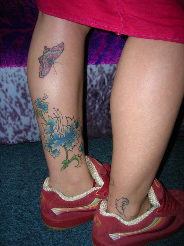 腿部蓝色花朵和蝴蝶纹身图案