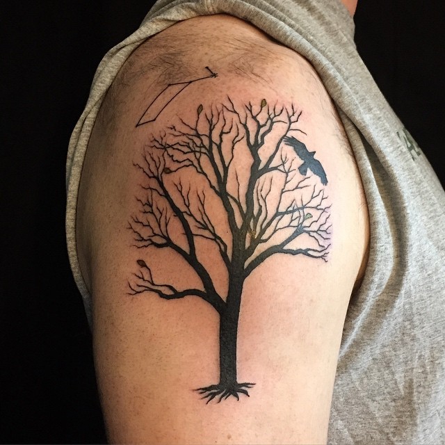 肩部黑色的树有几片叶子和乌鸦纹身图案