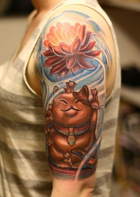 大臂彩色招财猫雕像和莲花纹身图案
