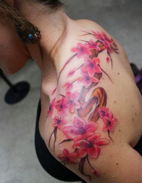 女士肩膀上的树枝和粉红色花朵纹身图案