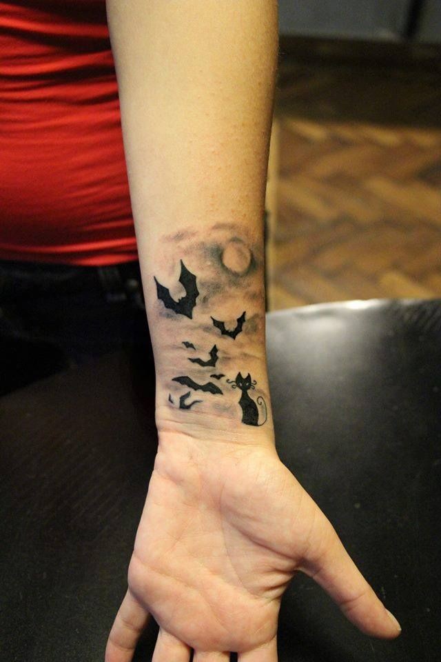 手腕黑色的猫和蝙蝠在夜间纹身图案