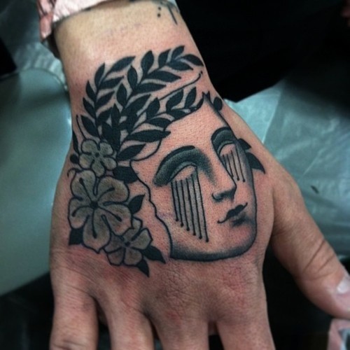 手背简朴的女人头与花纹身图案