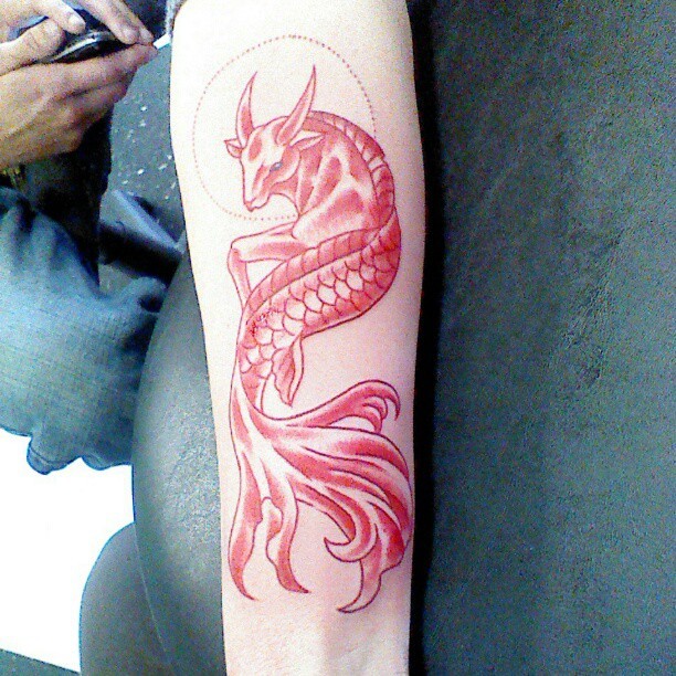 手臂微小的红摩羯鱼尾纹身图案